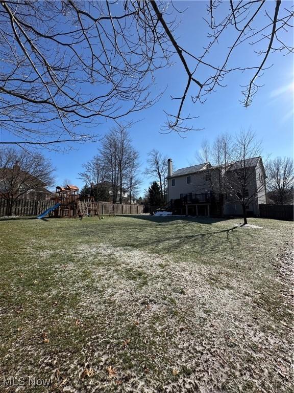 view of yard featuring a playground and fence