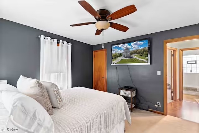 bedroom with a ceiling fan, light colored carpet, and baseboards