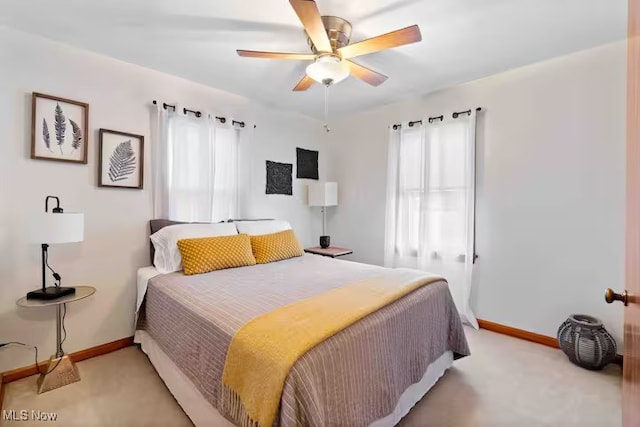 bedroom with light carpet, ceiling fan, and baseboards