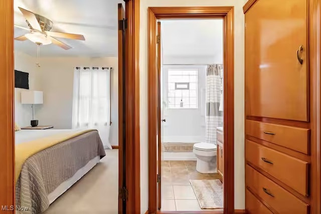 bedroom with connected bathroom and light tile patterned floors