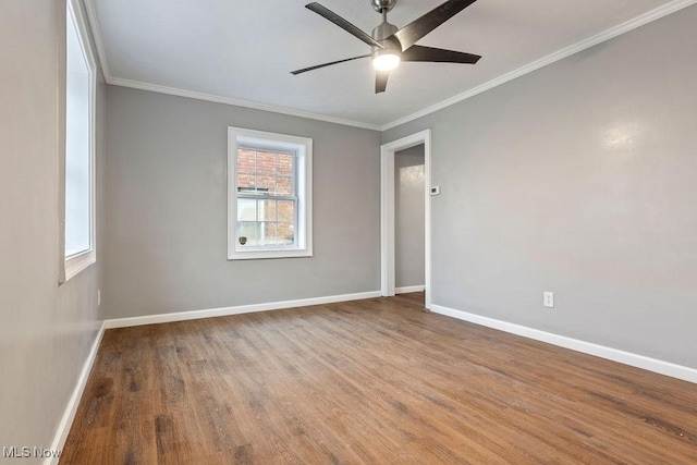 empty room featuring ceiling fan, ornamental molding, wood finished floors, and baseboards