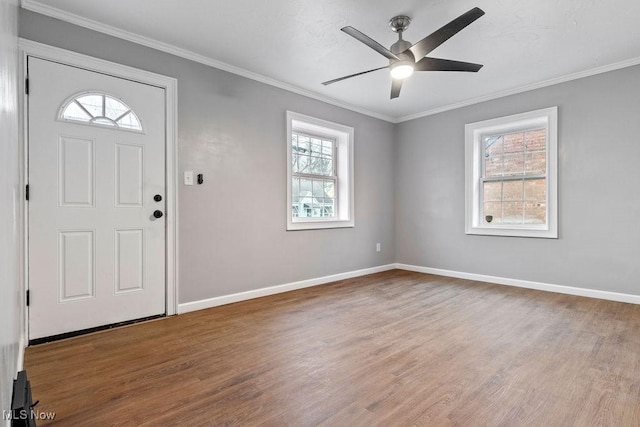 foyer with baseboards, crown molding, and wood finished floors