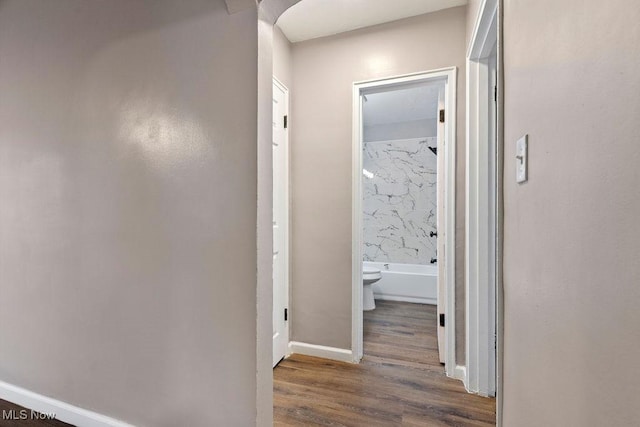 corridor with wood finished floors and baseboards