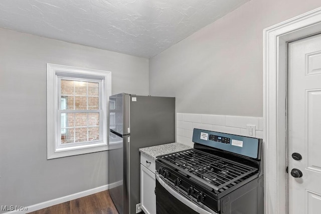 kitchen featuring dark wood-style floors, tasteful backsplash, baseboards, and stainless steel appliances