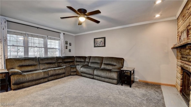 living area featuring a ceiling fan, a fireplace, crown molding, and baseboards