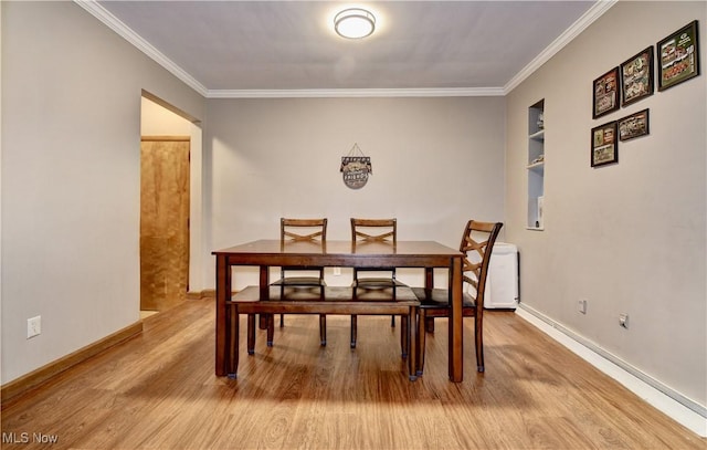 dining room with baseboards, wood finished floors, and crown molding