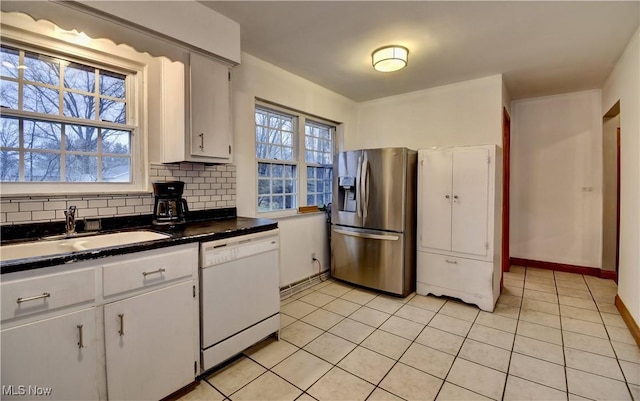 kitchen featuring white dishwasher, a sink, white cabinetry, stainless steel fridge with ice dispenser, and tasteful backsplash