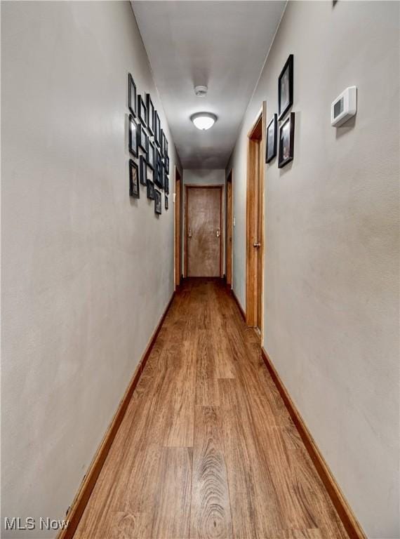 hall featuring wood finished floors and baseboards