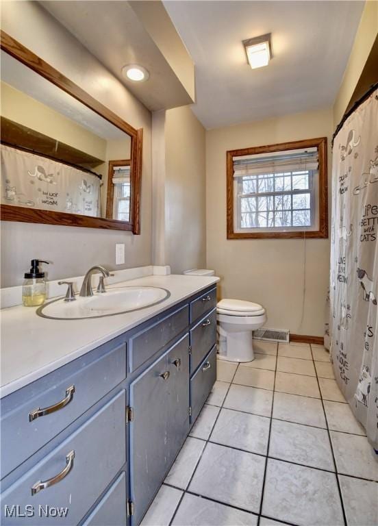 full bath featuring toilet, vanity, baseboards, visible vents, and tile patterned floors