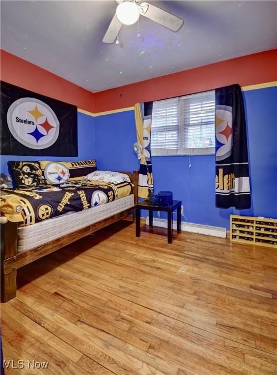 bedroom featuring baseboards and wood finished floors