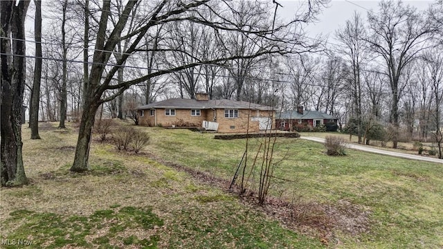 ranch-style house with concrete driveway, a front lawn, and brick siding