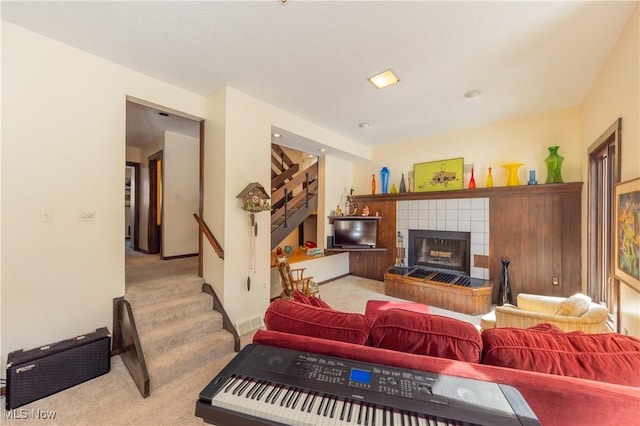 carpeted living room featuring a fireplace and stairs