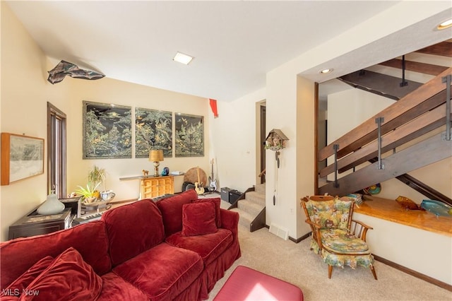 carpeted living area with stairs and baseboards