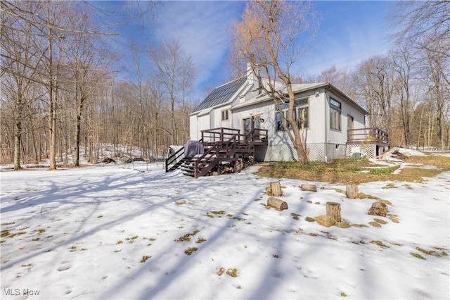 view of snow covered exterior featuring a wooden deck