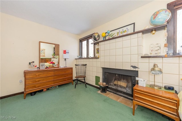 living area with carpet floors, baseboards, and a tile fireplace