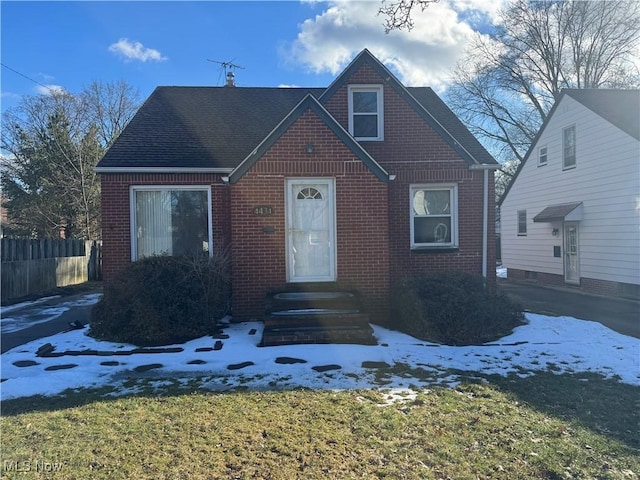 view of front of home featuring brick siding and fence