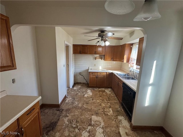 kitchen with black dishwasher, baseboards, tasteful backsplash, and a sink