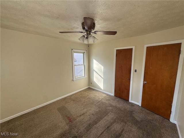 unfurnished bedroom featuring carpet flooring, ceiling fan, a textured ceiling, and baseboards