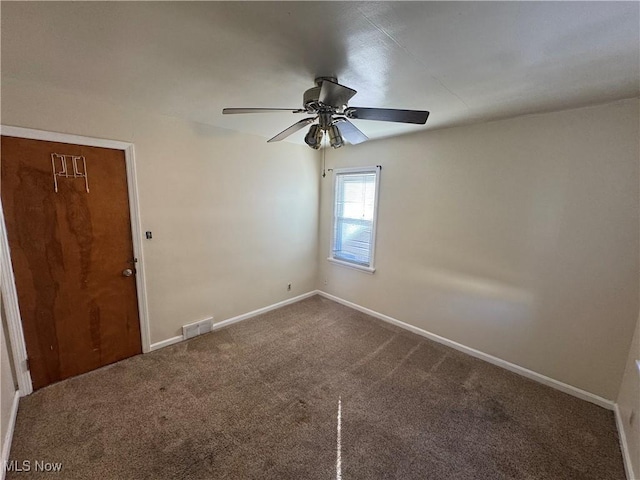 spare room with carpet floors, baseboards, visible vents, and ceiling fan