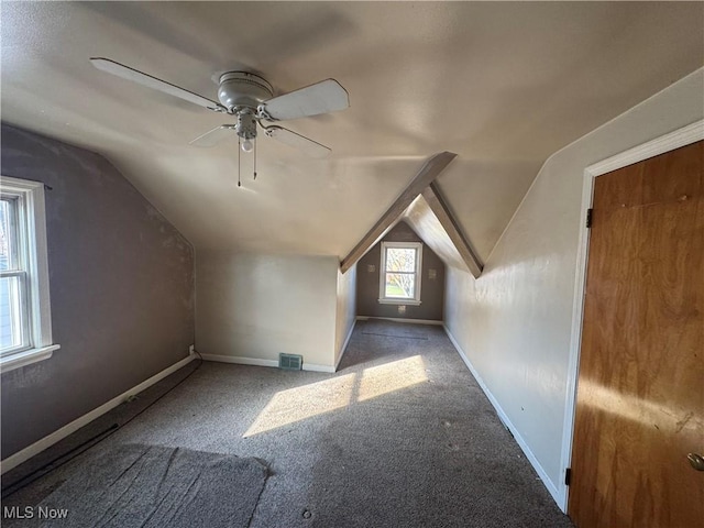 additional living space featuring visible vents, a ceiling fan, carpet flooring, vaulted ceiling, and baseboards