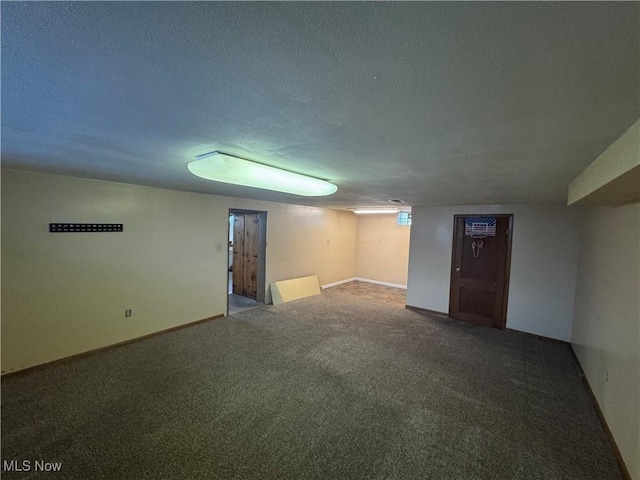 finished basement featuring a textured ceiling, carpet flooring, and baseboards