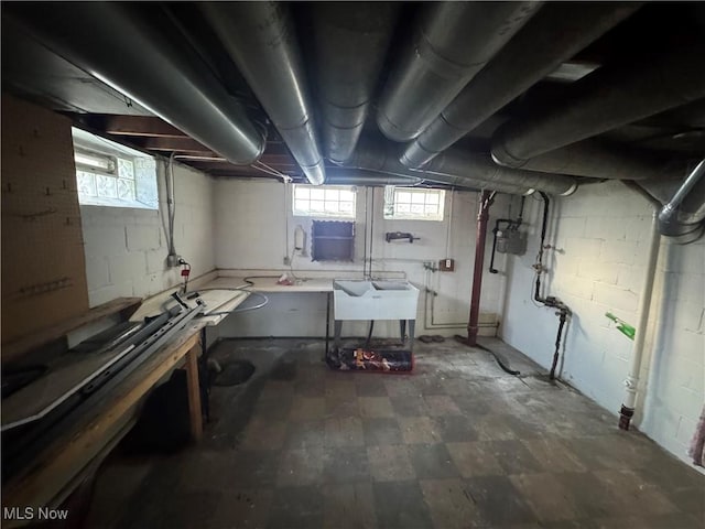 basement featuring a wealth of natural light and a sink