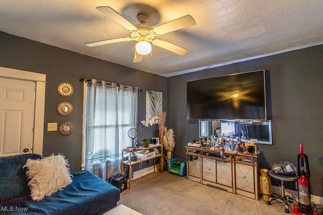 carpeted living area featuring a textured ceiling and a ceiling fan