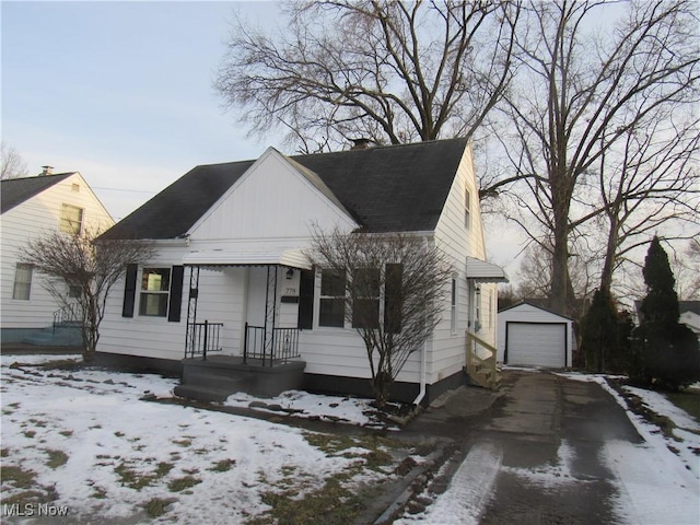 bungalow-style home with driveway, a chimney, an outdoor structure, and a detached garage