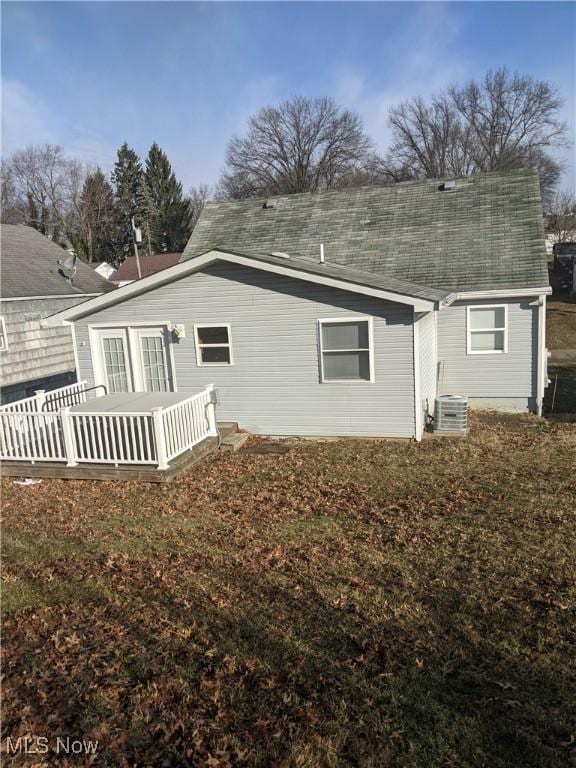 rear view of property with roof with shingles and central air condition unit