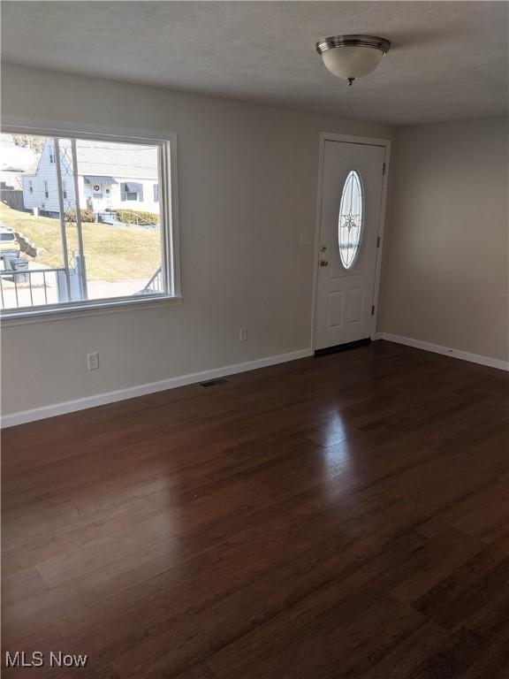 entryway featuring visible vents, baseboards, and dark wood finished floors