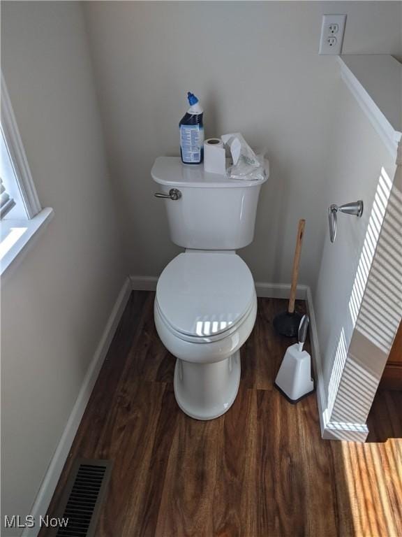 bathroom featuring baseboards, visible vents, toilet, and wood finished floors