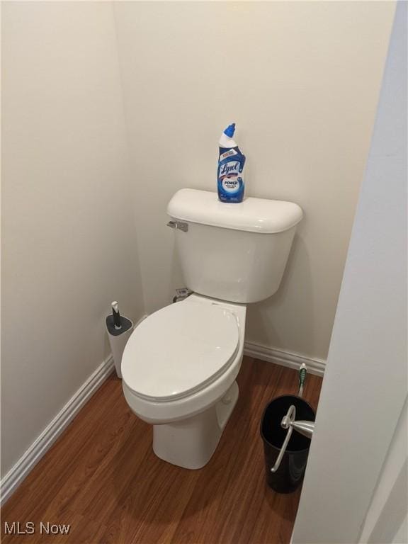 bathroom featuring toilet, baseboards, and wood finished floors