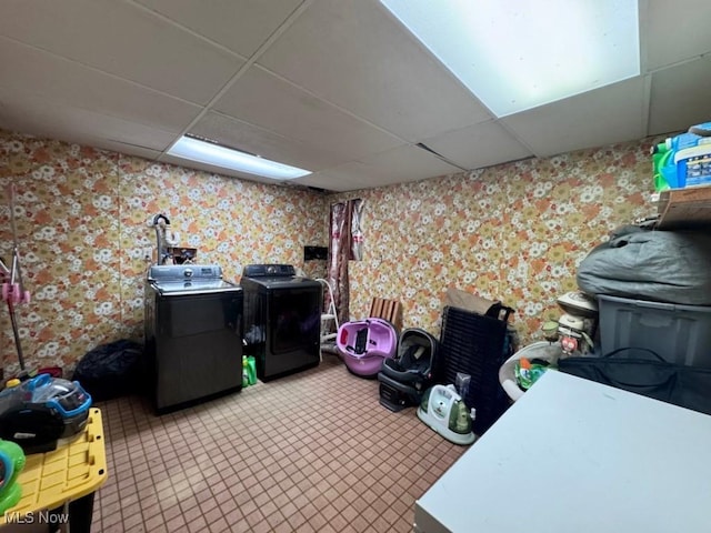 interior space with laundry area, washing machine and dryer, and wallpapered walls