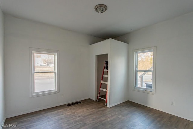 empty room with visible vents and wood finished floors