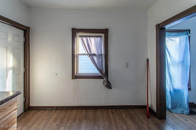 unfurnished bedroom with wood finished floors and baseboards