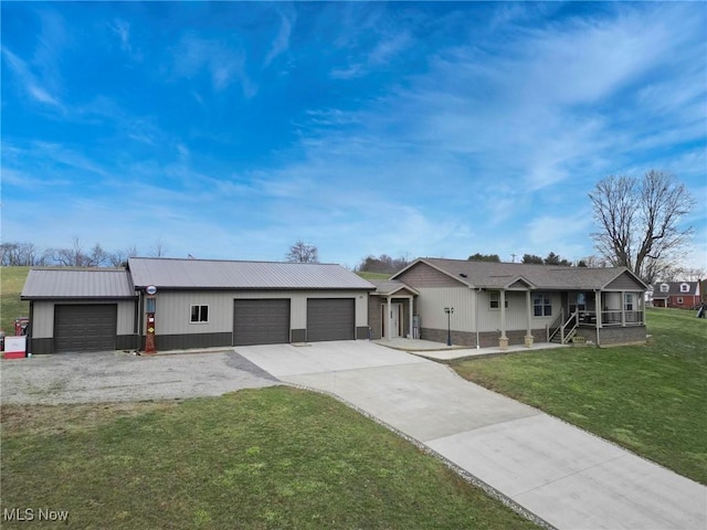 ranch-style home with driveway, a garage, metal roof, and a front yard