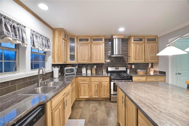 kitchen featuring decorative backsplash, appliances with stainless steel finishes, ornamental molding, a sink, and wall chimney range hood