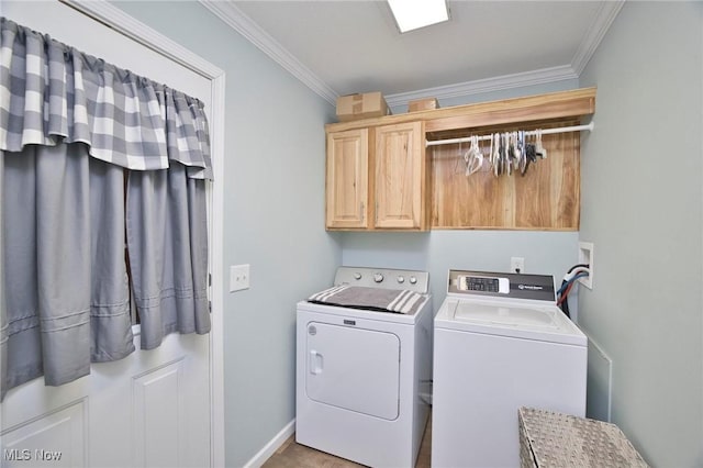 laundry room featuring cabinet space, washing machine and dryer, baseboards, and crown molding