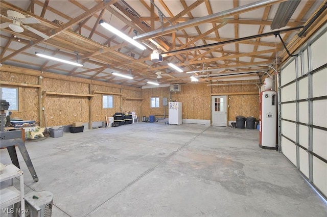 garage with a garage door opener, freestanding refrigerator, and water heater