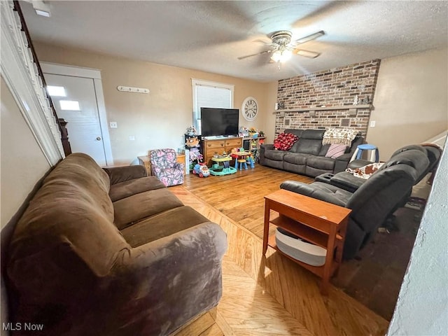 living room featuring ceiling fan and a textured ceiling