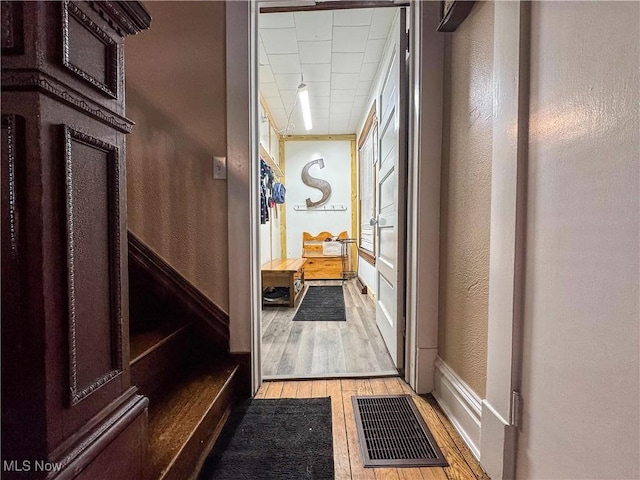 interior space with light wood-type flooring, baseboards, visible vents, and a textured wall