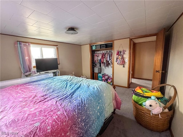 bedroom with carpet floors, baseboards, and a closet