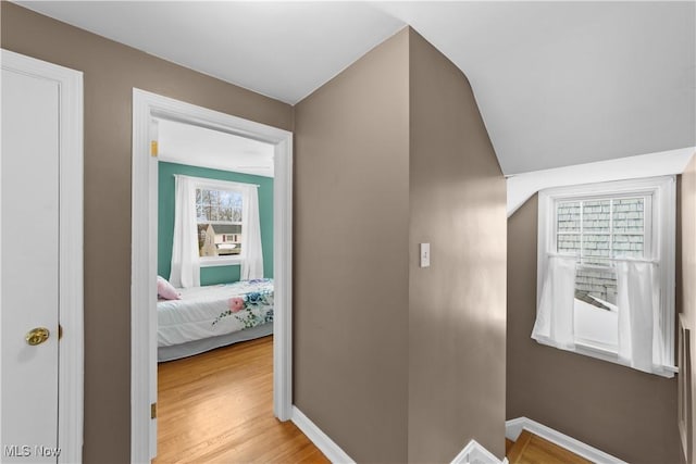 corridor featuring baseboards and light wood-style floors