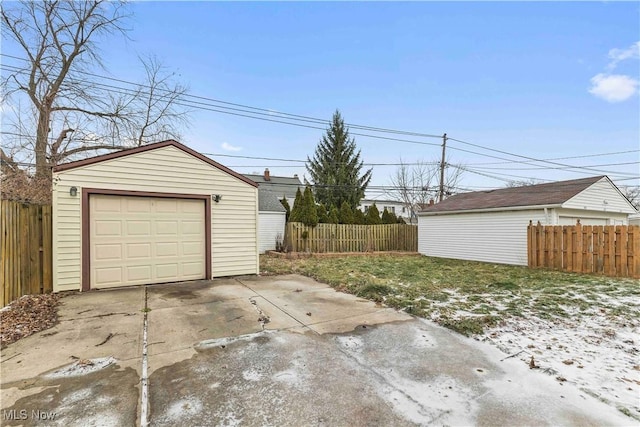 detached garage with fence and driveway