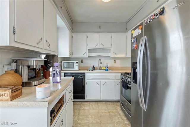 kitchen with stainless steel appliances, light countertops, backsplash, white cabinets, and a sink