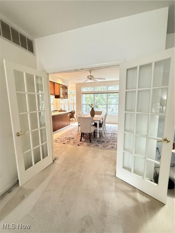 dining space featuring french doors, visible vents, and light colored carpet