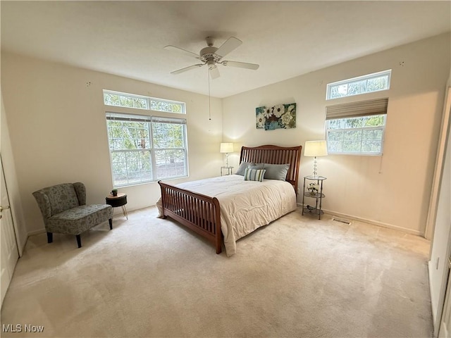 bedroom with multiple windows, a ceiling fan, and carpet flooring