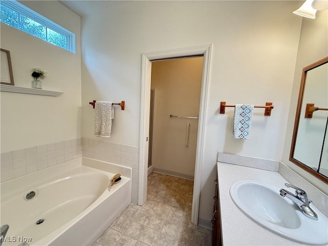 bathroom featuring a garden tub and vanity