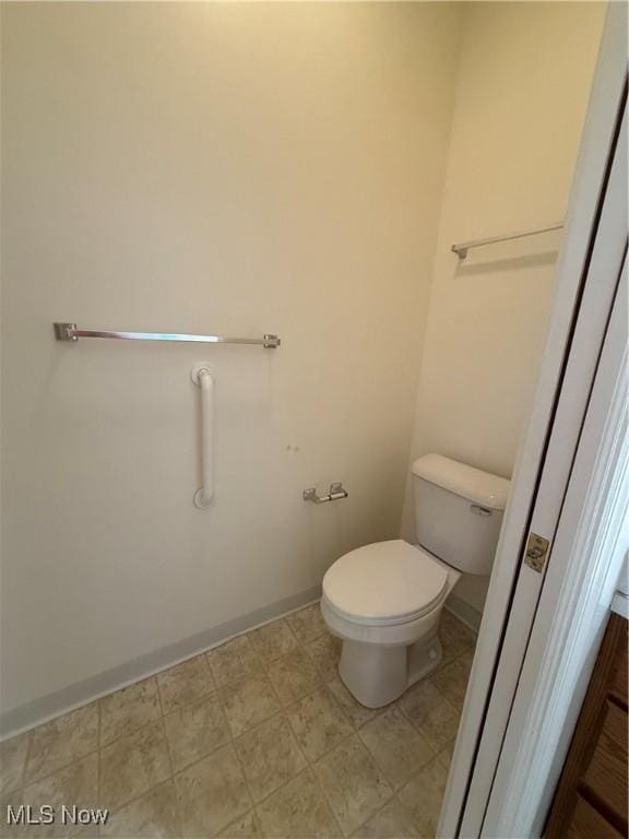 bathroom featuring toilet and baseboards