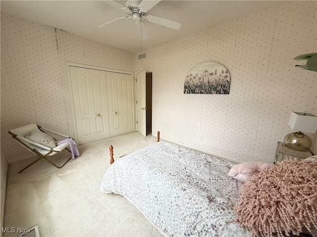 bedroom featuring ceiling fan, carpet floors, a closet, and wallpapered walls